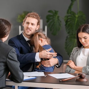 Couple with young daughter discussing divorce with an attorney - The Law Offices of Eve McClurg